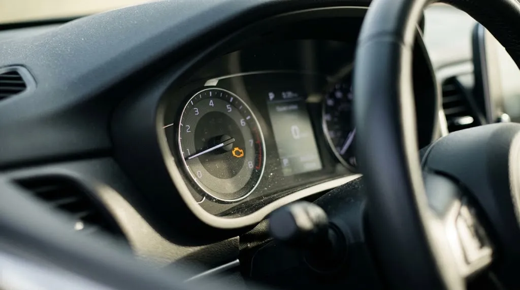 Close-up of an illuminated Check Engine Light on a car dashboard indicating a stored trouble code